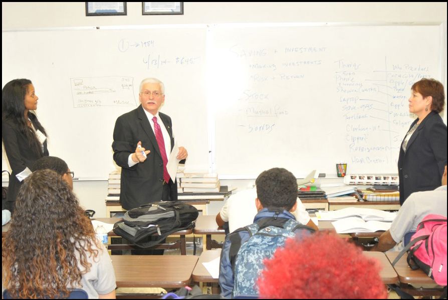 OCC representatives Courtney Cook, Tom Melo, and Patricia Acosta (left to right) discuss financial literacy topics, including saving and budgeting, to students of Washington Math Science Technology Public Charter School.