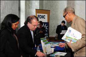 Congressional Affairs Specialist Arnold Cohen and Technical Assistant Courtney Cook offer materials, including OCC's Help With My Bank booklet, for a National Consumer Protection Week attendee.